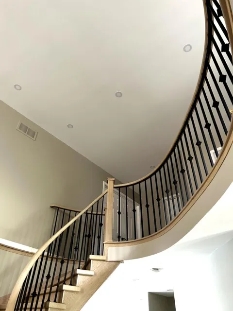Smooth finished ceiling above a curved staircase in EPF’s Burlington project gallery